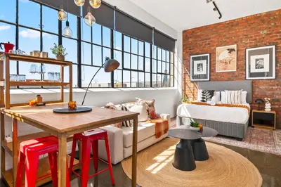 a living room with a brick wall at Trendy Salt River Loft Apartment in Cape Town