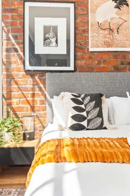 a bed in a room with a brick wall at Trendy Salt River Loft Apartment in Cape Town