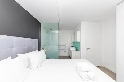 a bedroom with a large white bed with white pillows at Modern Sea View Retreat with Pool & Inverter Horizon Bay 1405 in Cape Town