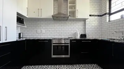 a black and white kitchen with a stove top oven at Homey Central Apartment By ARPA in Stellenbosch