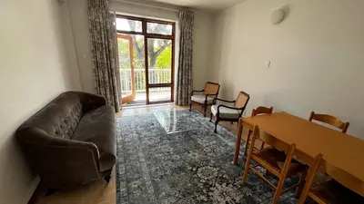 a living room with a couch and a table at Homey Central Apartment By ARPA in Stellenbosch