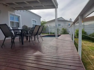 a wooden deck with a table and chairs on it at Chelmsford Close Pinehurst - Excellent location! in Oakdale