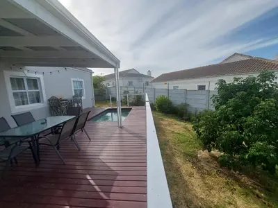 a wooden deck with a table and chairs on a house at Chelmsford Close Pinehurst - Excellent location! in Oakdale