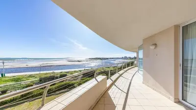 a balcony with a view of the beach at Lagoon Beach Gem 127 Pool, Views & Sea Breeze in Cape Town