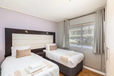 a bedroom with two beds and a window at Lagoon Beach 124A by CTHA in Cape Town