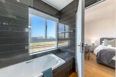 a bathroom with a bath tub and a window at Spinnakers 9 by HMH in Cape Town
