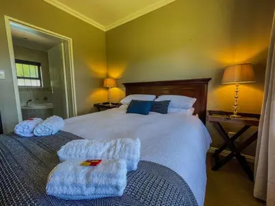 a bedroom with a large bed with towels on it at Spacious mountain-view haven in Stellenbosch