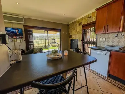 a kitchen with a table and chairs in a room at Spacious mountain-view haven in Stellenbosch