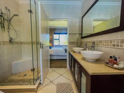a bathroom with two sinks and a shower at Spacious mountain-view haven in Stellenbosch