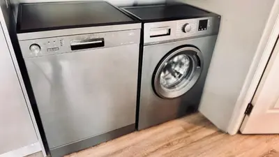 a stainless steel washer and dryer in a room at 2 Bedroom, 4 Sleeper Hidden Gem Minutes from Blouberg Beach Front in Cape Town