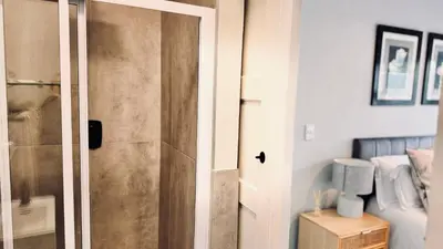 a sliding door in a room with a bed at 2 Bedroom, 4 Sleeper Hidden Gem Minutes from Blouberg Beach Front in Cape Town