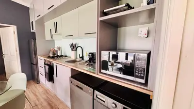 a small kitchen with a microwave and a counter at 2 Bedroom, 4 Sleeper Hidden Gem Minutes from Blouberg Beach Front in Cape Town