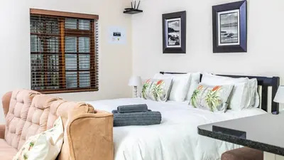 a bedroom with a large white bed with a table at Campbell's Corner in Cape Town
