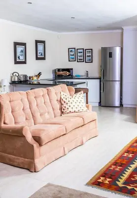 a brown couch in a living room with a kitchen at Campbell's Corner in Cape Town