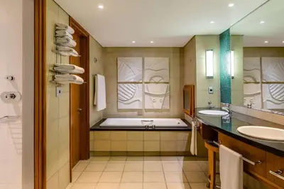 a bathroom with two sinks and a bath tub at Arabella Hotel, Golf and Spa in Kleinmond