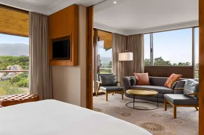 a hotel room with a bed and a living room at Arabella Hotel, Golf and Spa in Kleinmond