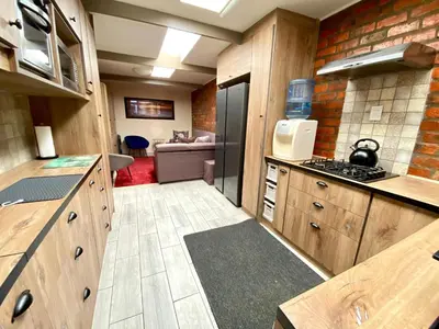 a large kitchen with wooden cabinets and a stove at Modern Van Riebeeck Park Accomodation in Worcester