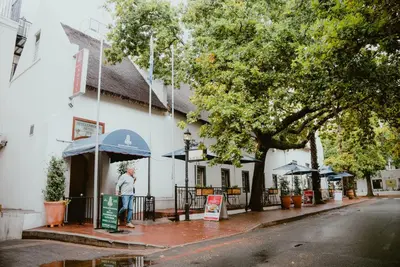 a man standing outside of a building at The Stellenbosch Hotel in Stellenbosch