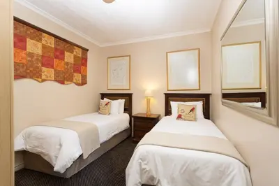 two beds in a small room with twoermottermott at The Stellenbosch Hotel in Stellenbosch