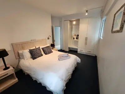 a bedroom with a large white bed in it at Seaview Serenity Strand in Strand