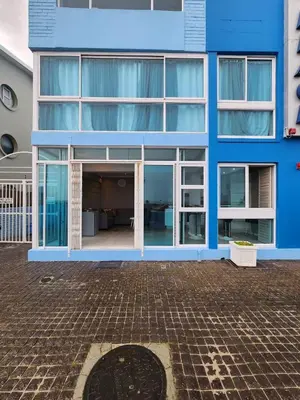 a blue building with large windows and a courtyard at Seaview Serenity Strand in Strand