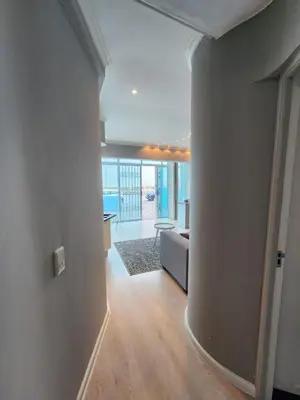 a hallway with a living room with a couch and a table at Seaview Serenity Strand in Strand