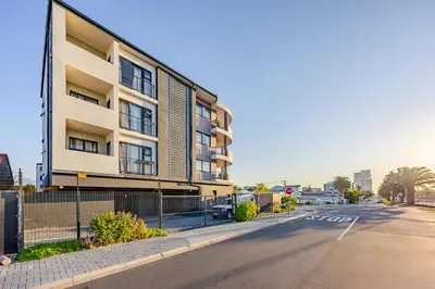 an empty street in front of a building at Contemporary Modern 1 Bedroom-19B, Blouberg in Cape Town