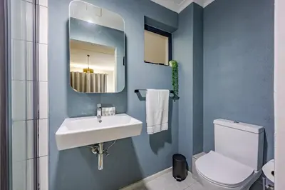 a bathroom with a sink and a toilet and a mirror at Contemporary Modern 1 Bedroom-19B, Blouberg in Cape Town