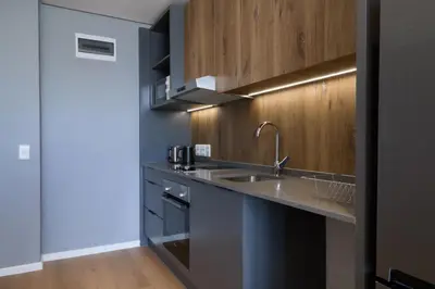a kitchen with a sink and wooden cabinets at Riverlands Luxury Apartments by City Club in Cape Town