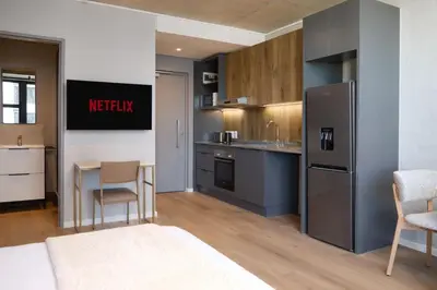 a kitchen with a refrigerator and a table and chairs at Riverlands Luxury Apartments by City Club in Cape Town