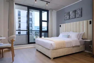 a bedroom with a large bed and a large window at Riverlands Luxury Apartments by City Club in Cape Town