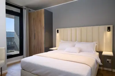 a bedroom with a large white bed with a window at Riverlands Luxury Apartments by City Club in Cape Town