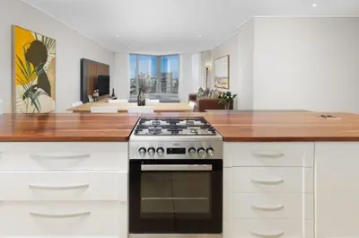 a kitchen with a stove and a living room at Ashley On Beach 1104 Prestige Style in Strand