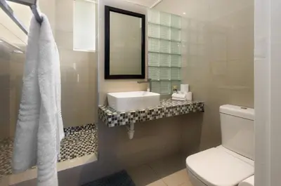a white bathroom with a sink and a toilet at Ashley On Beach 1104 Prestige Style in Strand