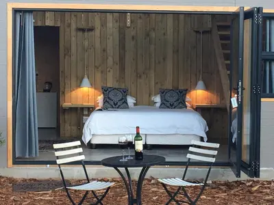a bedroom with a bed and a table with a bottle of wine at PicardiPlace in Rawsonville