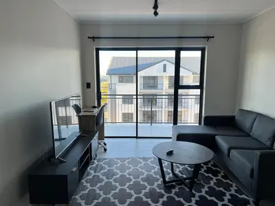 a living room with a couch and a table at The black and white suite in Blackheath