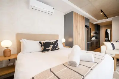 a bedroom with a large white bed with towels on it at S500 Riverlands - Lux Studio Apartment in Cape Town