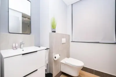 a bathroom with a white toilet and a sink at S500 Riverlands - Lux Studio Apartment in Cape Town