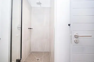 a shower with a glass door in a bathroom at S500 Riverlands - Lux Studio Apartment in Cape Town