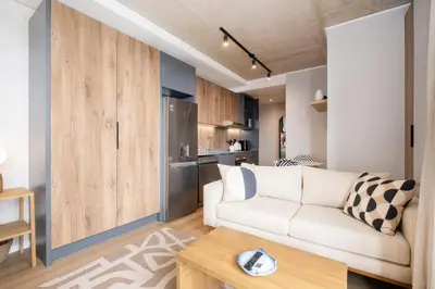 a living room with a couch and a table at S500 Riverlands - Lux Studio Apartment in Cape Town