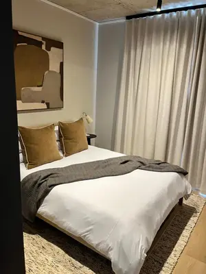 a bedroom with a bed with white sheets and a window at Riverlands 2Bedroom Apartment with Mountain Views in Cape Town