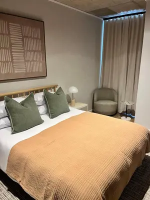 a bedroom with a large bed and a chair at Riverlands 2Bedroom Apartment with Mountain Views in Cape Town