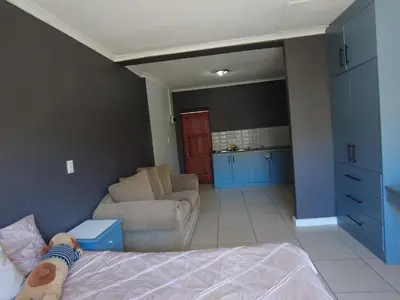 a person laying on a bed in a bedroom at Studio Flat Bayside in Cape Town