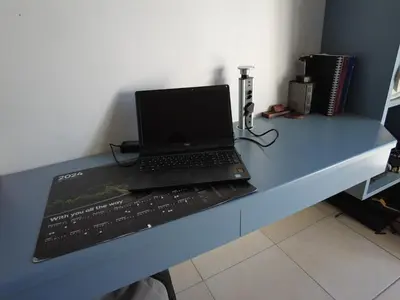 a laptop computer sitting on top of a blue desk at Studio Flat Bayside in Cape Town