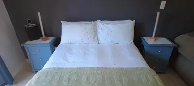a bedroom with a bed with two nightstands and two pillows at Studio Flat Bayside in Cape Town
