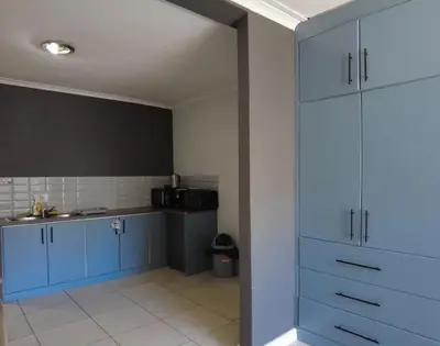 a kitchen with blue cabinets and a sink at Studio Flat Bayside in Cape Town