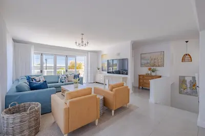 a living room with a blue couch and chairs at Serenity on 6th Luxury holiday home in Hermanus