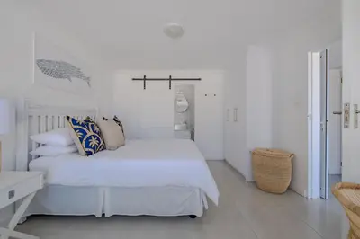 a white bedroom with a white bed and white walls at Serenity on 6th Luxury holiday home in Hermanus