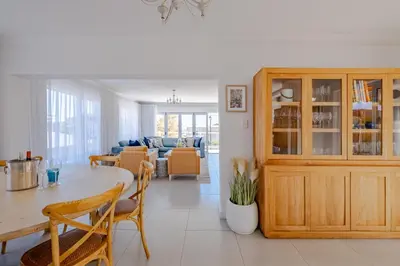 a dining room and living room with a table and chairs at Serenity on 6th Luxury holiday home in Hermanus
