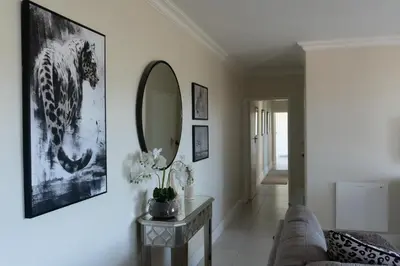 a living room with a mirror and a couch at Begonias Eden in Helderberg